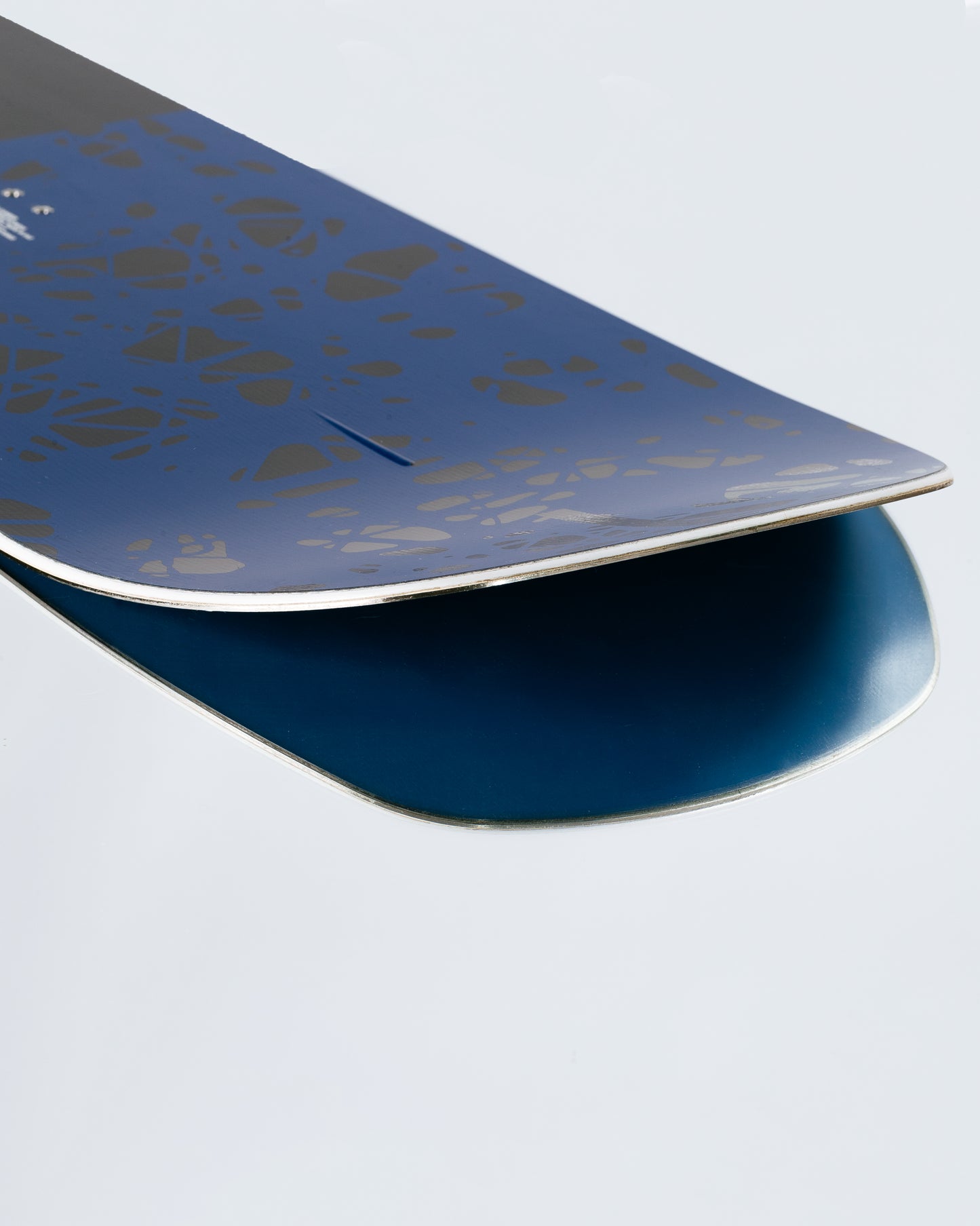 The tail and base of the freeride snowboard with HotRods and PowerSlide base. Warden 2025 | Rome Snowboards™ 2025.