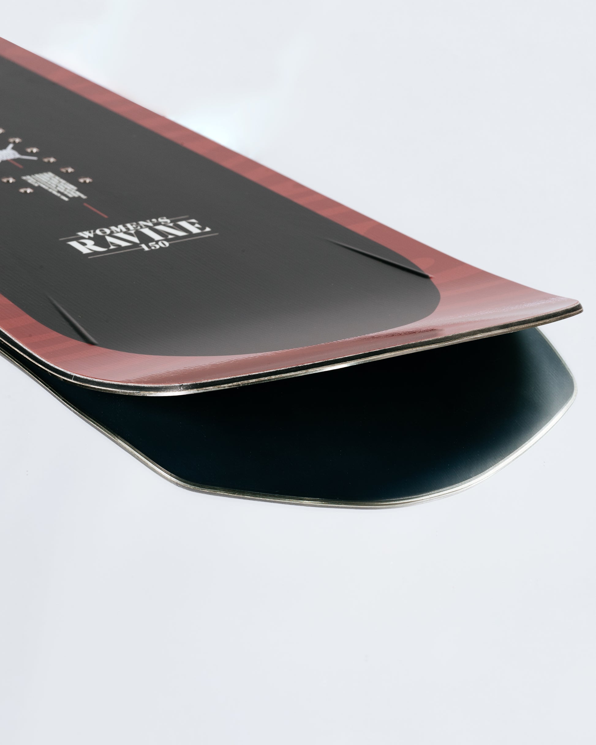 The tail and base of the powder snowboard with HotRods and SinterStrong base. Women's Ravine 2025 | Rome Snowboards™